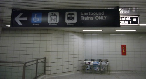 Sign in ‘Helvetica’ with arrow and three pictographs covers old sign