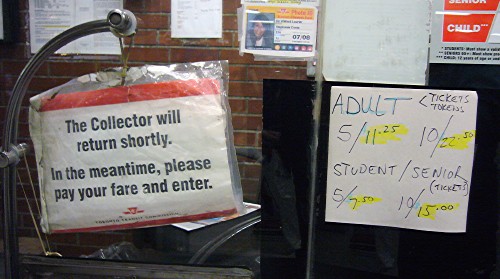 Preprinted sign reads The Collector will return shortly. In the meantime, please pay your fare and enter. Handwritten sign alongside gives fares (with yellow highlighting)
